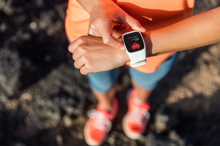 Persona utilizando un reloj inteligente para monitorear su actividad física, control de salud y hábitos de autocuidado en la vida diaria