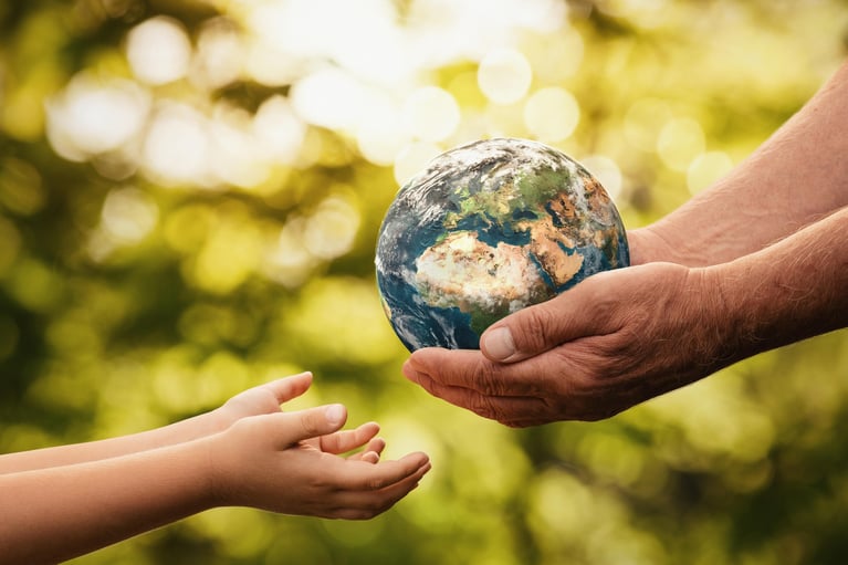 mains d’un aîné donnant la terre à un enfant 0
