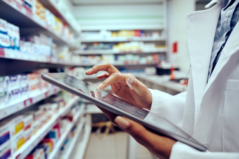 Pharmacist with a tablet entering info 