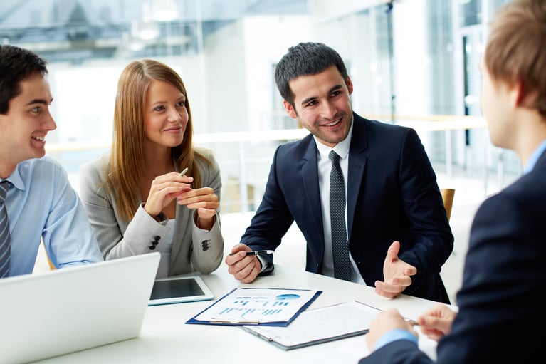 Business colleagues sitting at a bright conference table during a meeting.