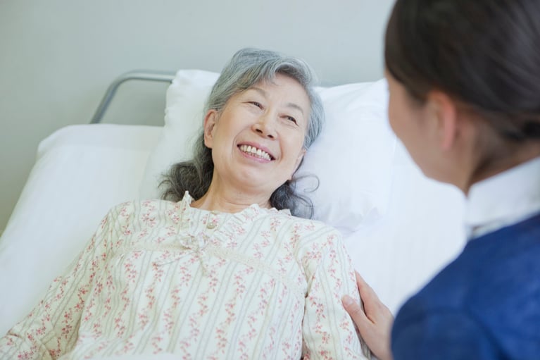 senior_woman_lying_in_bed_talk.jpg