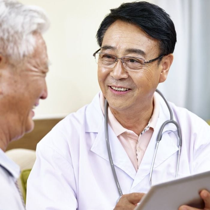 Asian doctor talking to a smiling patient 121995