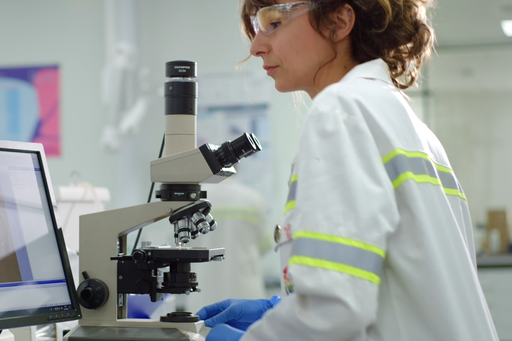 Chercheuse en laboratoire devant son microscope