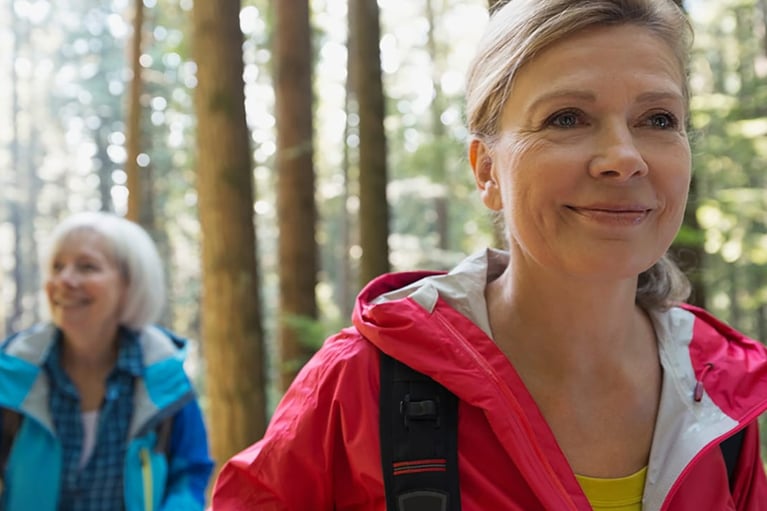 Senior women hiking in sunny woods 1280x720