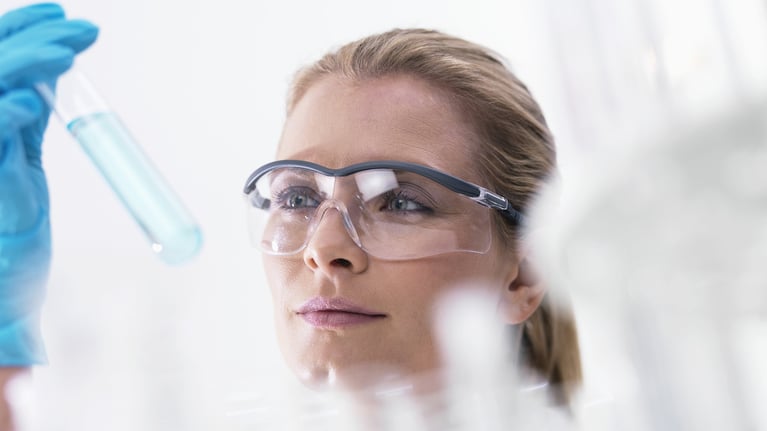 female scientist examining tube