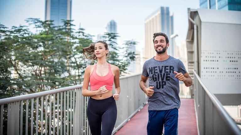 couple running on footbridge