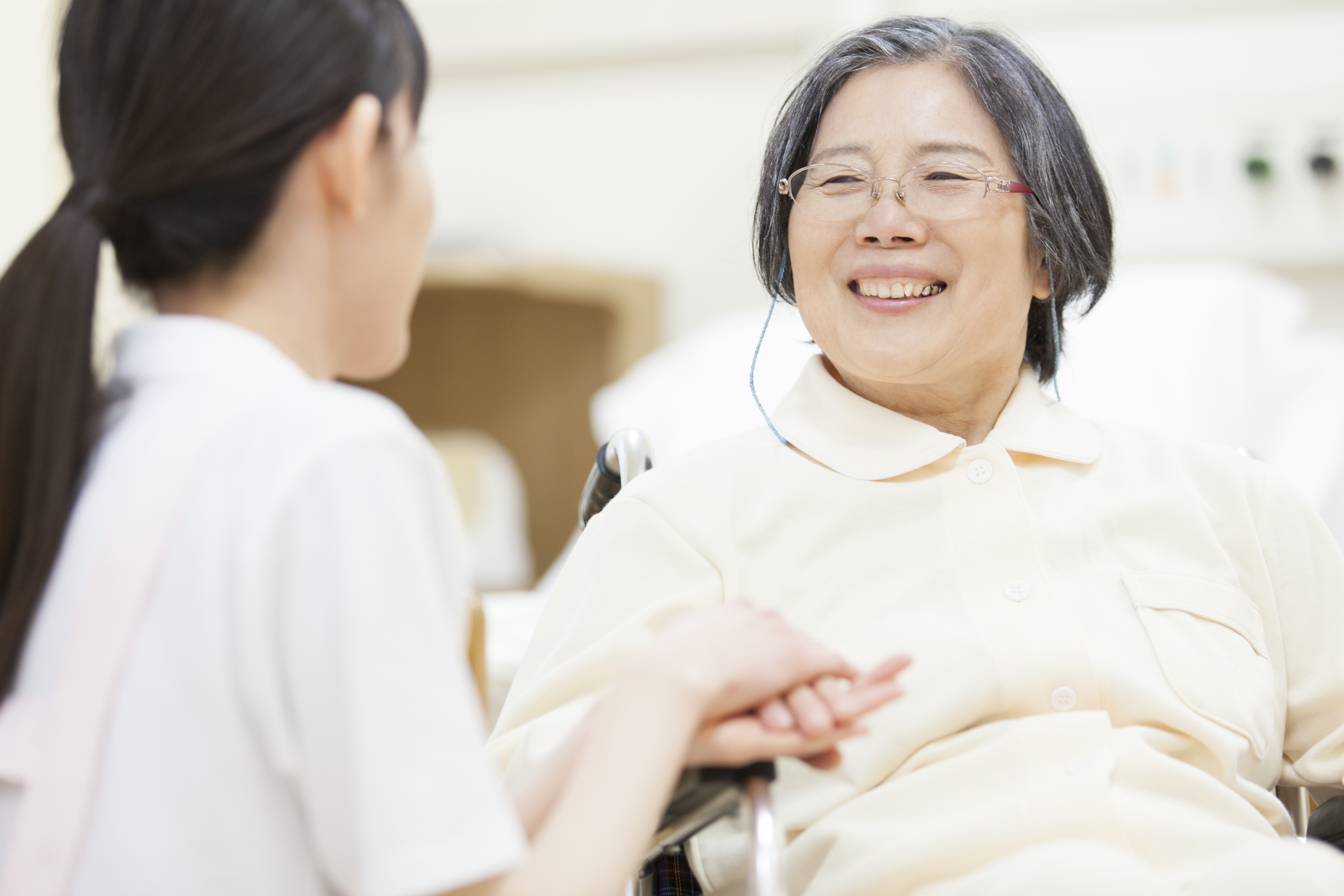 nurse touching patient_s hand in wheelchair.jpeg