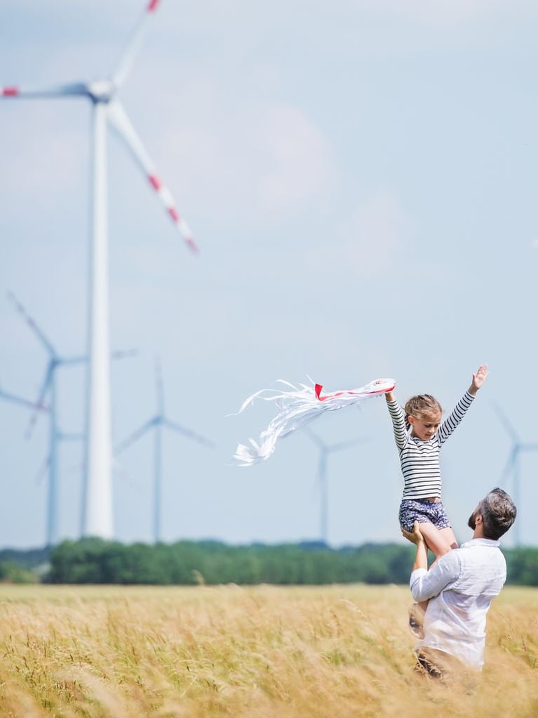 father_and_daughter_in_front_of_wind_farm.jpeg