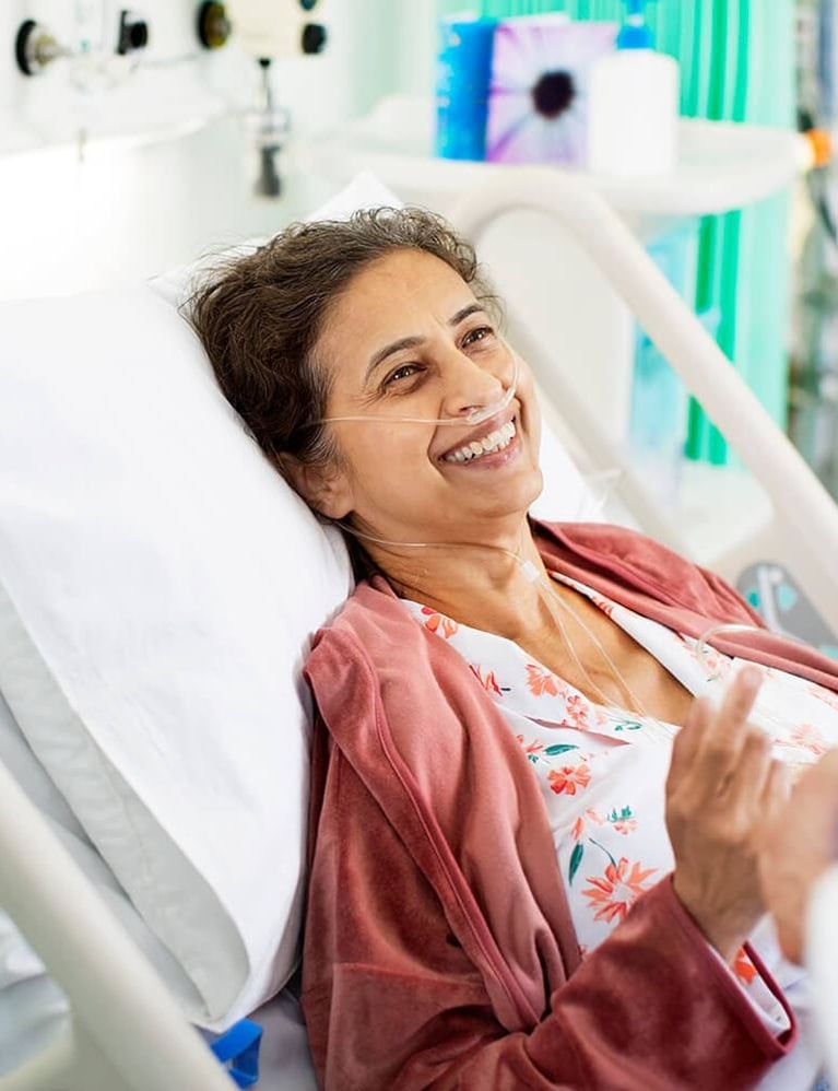 smiling patient in hospital bed 0
