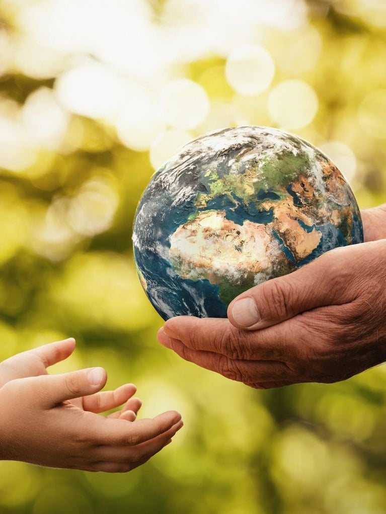 senior hands giving earth to a child
