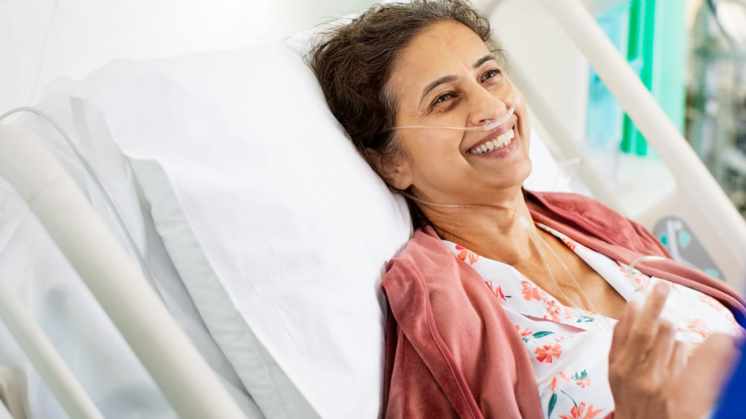 smiling patient in hospital bed