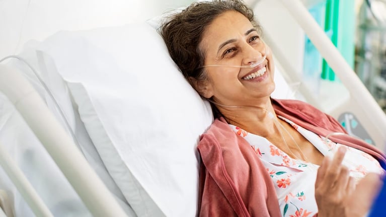 smiling patient in hospital bed