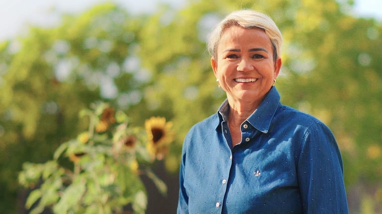 Eliane Quintela smiling outdoors at the camera