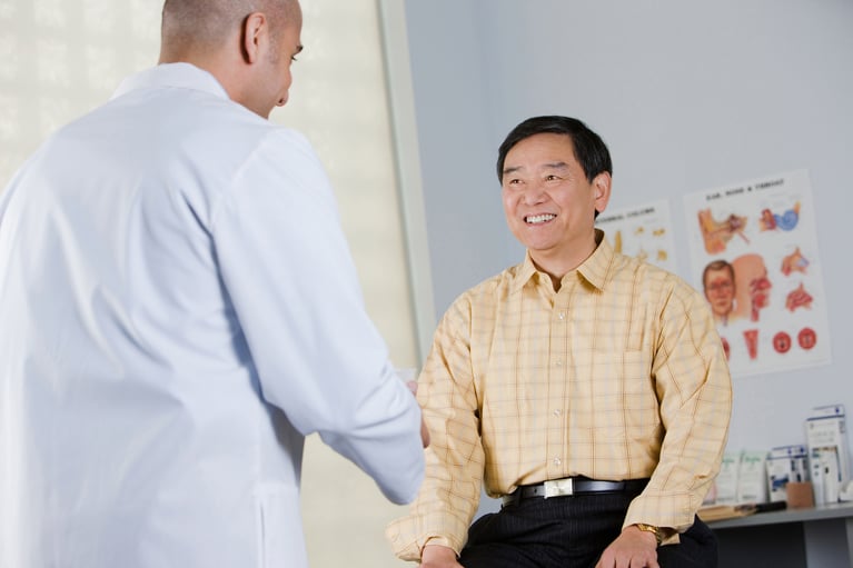 Patient during a consultation with a healthcare professional discussing prostate cancer treatment, symptom management, and fatigue.