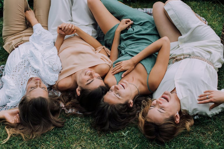 Cuatro p tumbadas sobre el césped al aire libre, interacción social y bienestar, representando libertad, calidad de vida y decisiones informadas sobre anticoncepciómujeres