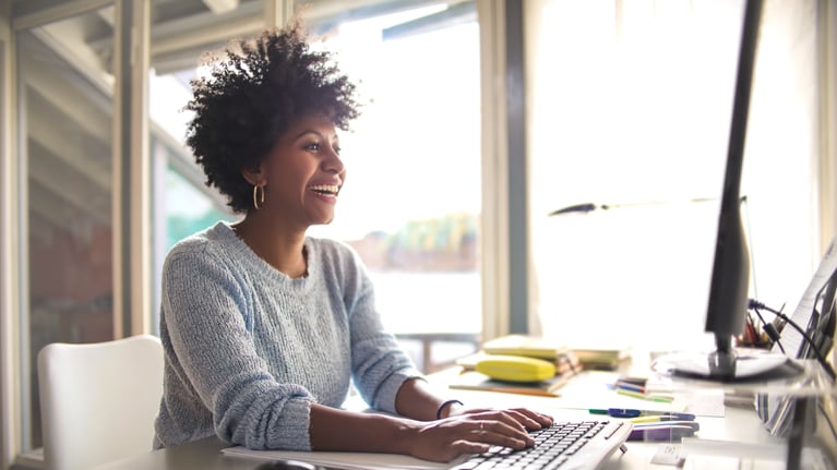 smiling_woman_working_in_home_office.jpeg