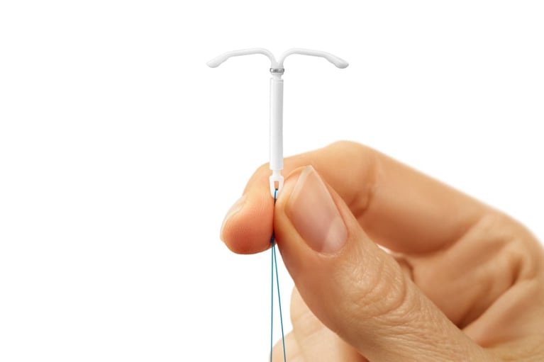Mano sostiene un dispositivo intrauterino (SIU) en forma de T, método anticonceptivo de larga duración para la planificación familiar