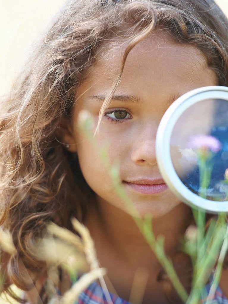 Girl playing with magnifyer