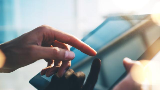 Close-up of hands using a tablet.