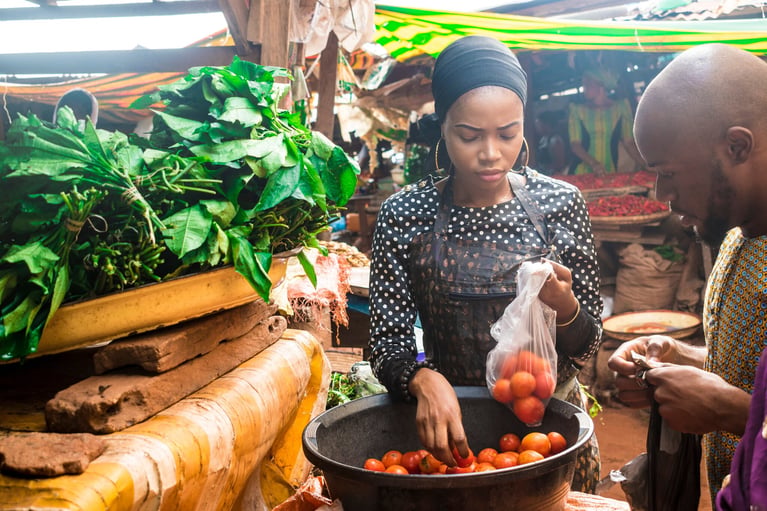 foodchainpartner-young-woman-selling-tomatoes-0.jpg