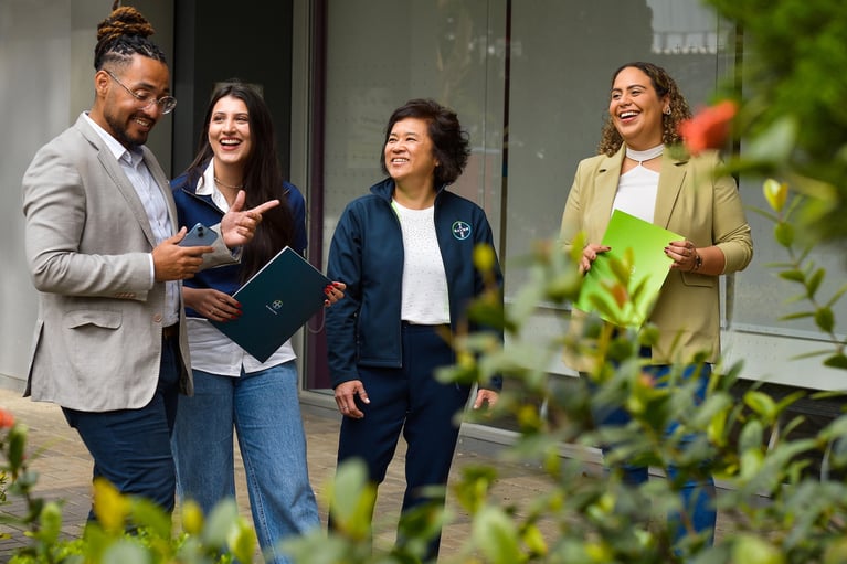 four-colleagues-stand-outdoors-in-discussion.jpg