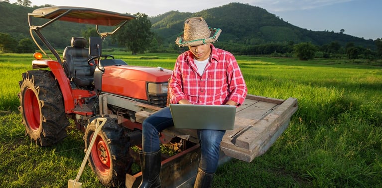man-with-laptop-on-tractor.jpg