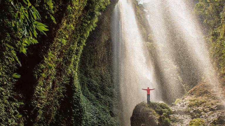 person_standing_at_a_waterfall.jpeg