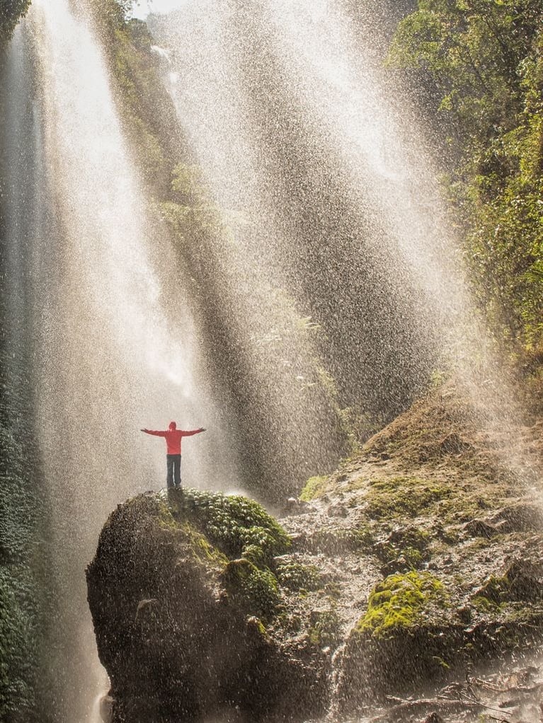 person_standing_at_a_waterfall.jpeg