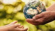 Senior hands giving earth to a child