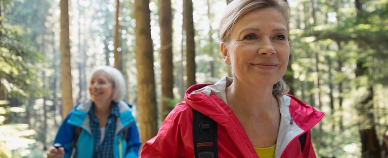 Senior_women_hiking_in_sunny_woods_1440x509.jpg